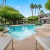 a swimming pool with a deck and trees in the background