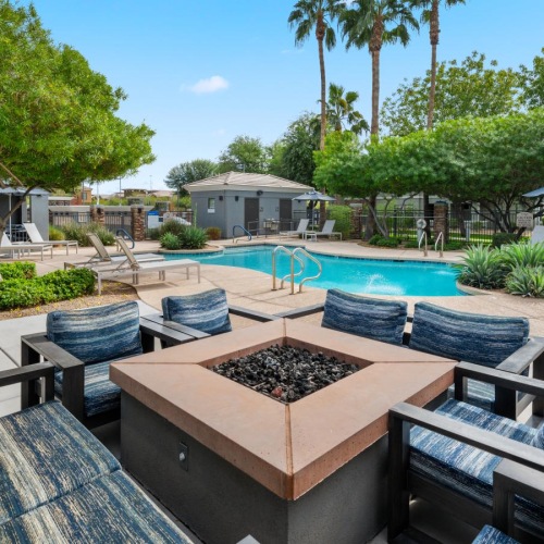 Relax and unwind poolside a pool with chairs and a table