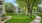 a large green lawn with trees and buildings