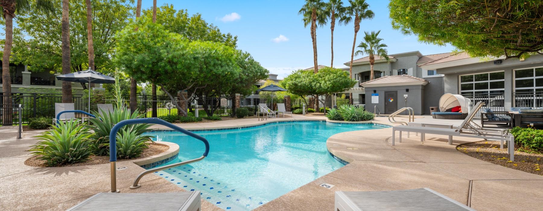 a swimming pool with a deck and trees in the background